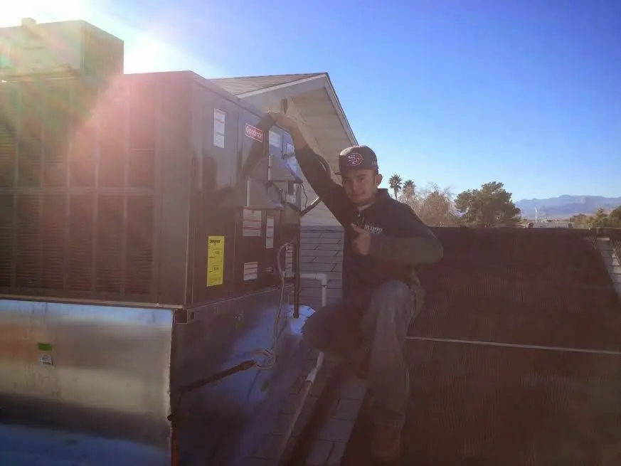HVAC technician performing AC Tune-Up on a rooftop unit in Lakewood Park